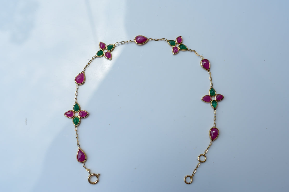 Gold bracelet with ruby and emerald quatrefoil clusters