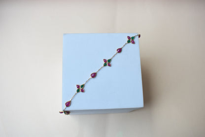 Gold bracelet with ruby and emerald quatrefoil clusters