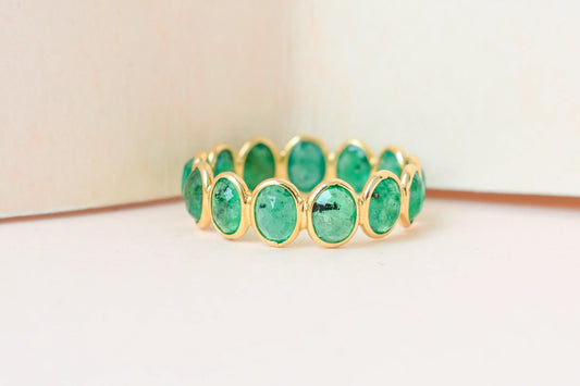Oval-cut emerald scalloped eternity ring in 18K gold
