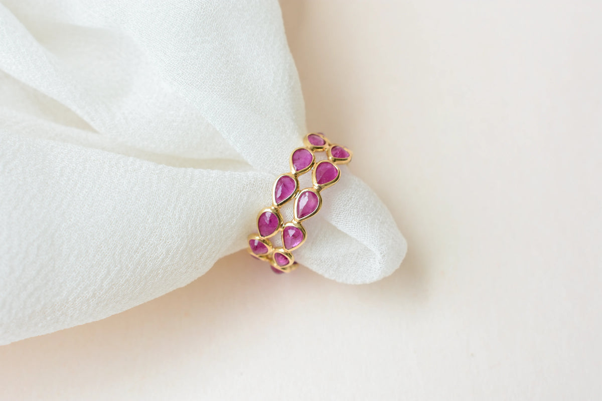 Pear-cut ruby woven double-row eternity ring in 18K gold