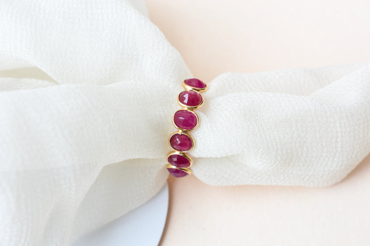 Oval-cut ruby single-row eternity ring in 14K gold