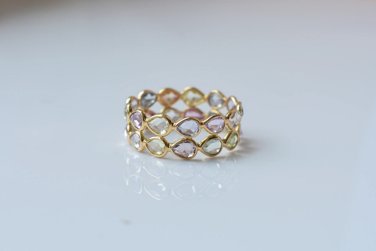 Pear-cut pastel multicolor sapphire eternity ring in 18K gold