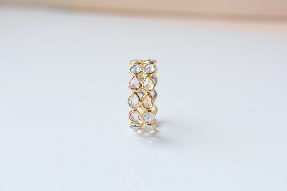 Pear-cut pastel multicolor sapphire eternity ring in 18K gold