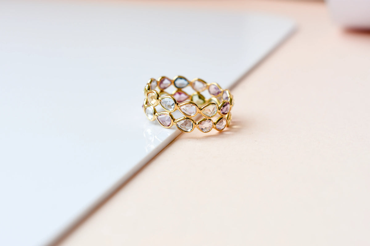 Pear-cut pastel multicolor sapphire eternity ring in 18K gold