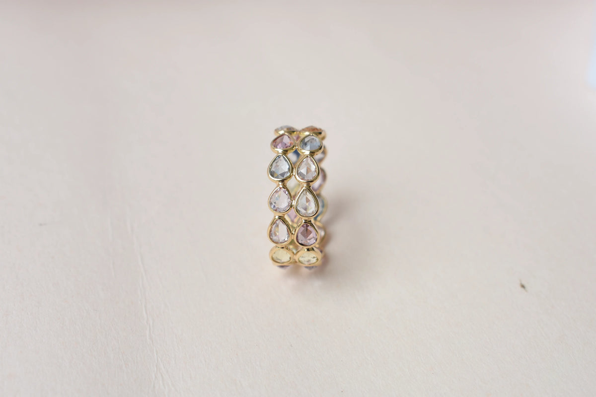 Pear-cut pastel multicolor sapphire eternity ring in 18K gold