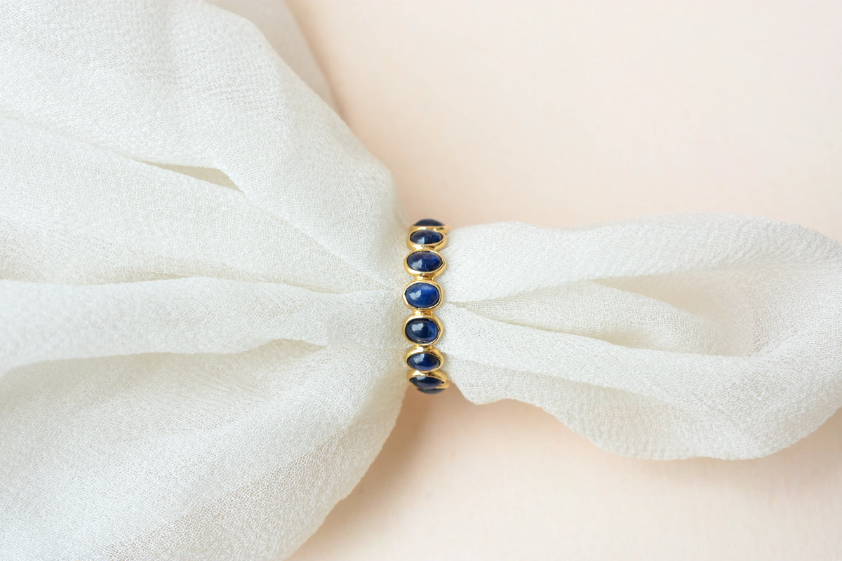 Oval cabochon blue sapphire eternity ring in 18K gold