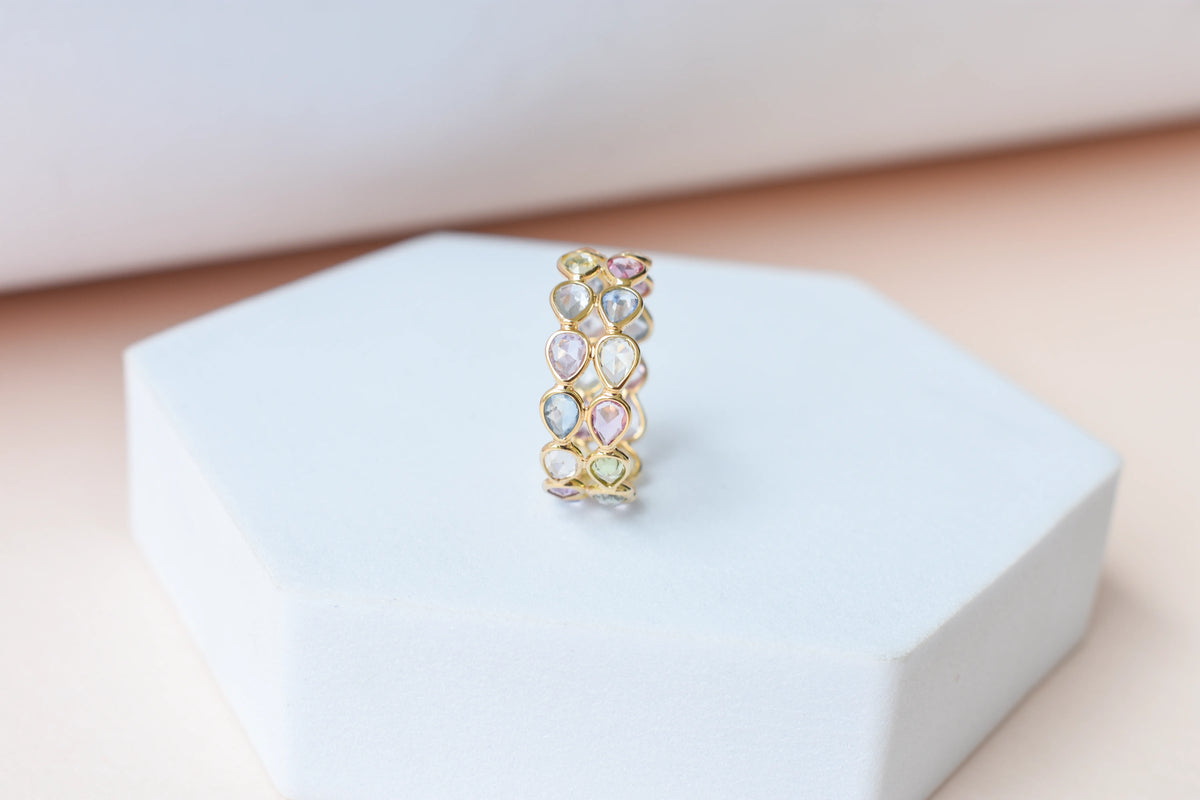 Pear-cut pastel multicolor sapphire eternity ring in 18K gold