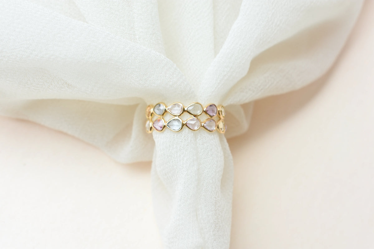 Pear-cut pastel multicolor sapphire eternity ring in 18K gold