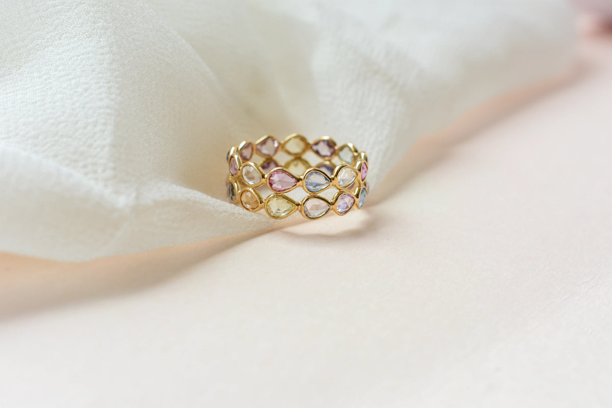 Pear-cut pastel multicolor sapphire eternity ring in 18K gold