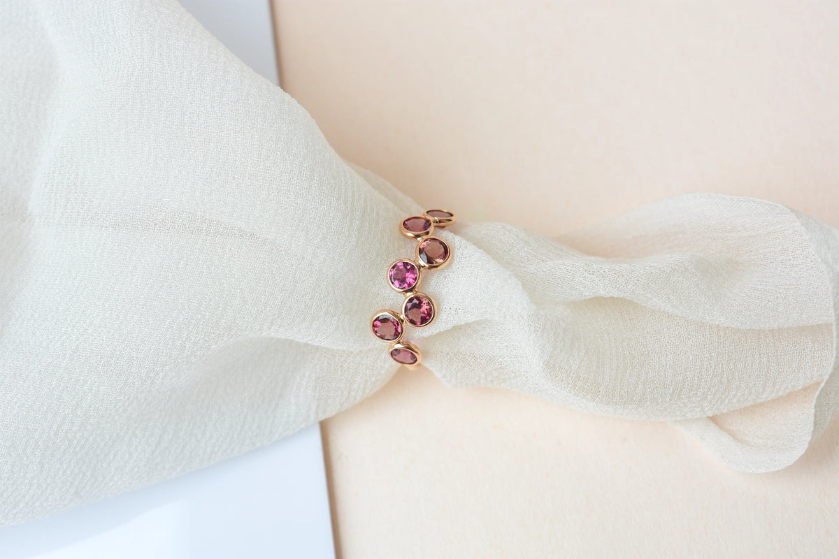 Round-cut pink gemstone wavy row ring in 18K gold