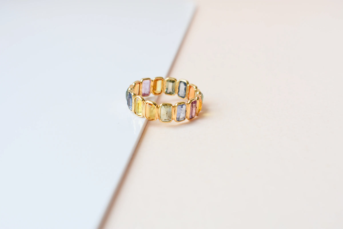 Emerald-cut multicolor sapphire eternity ring in 18K gold