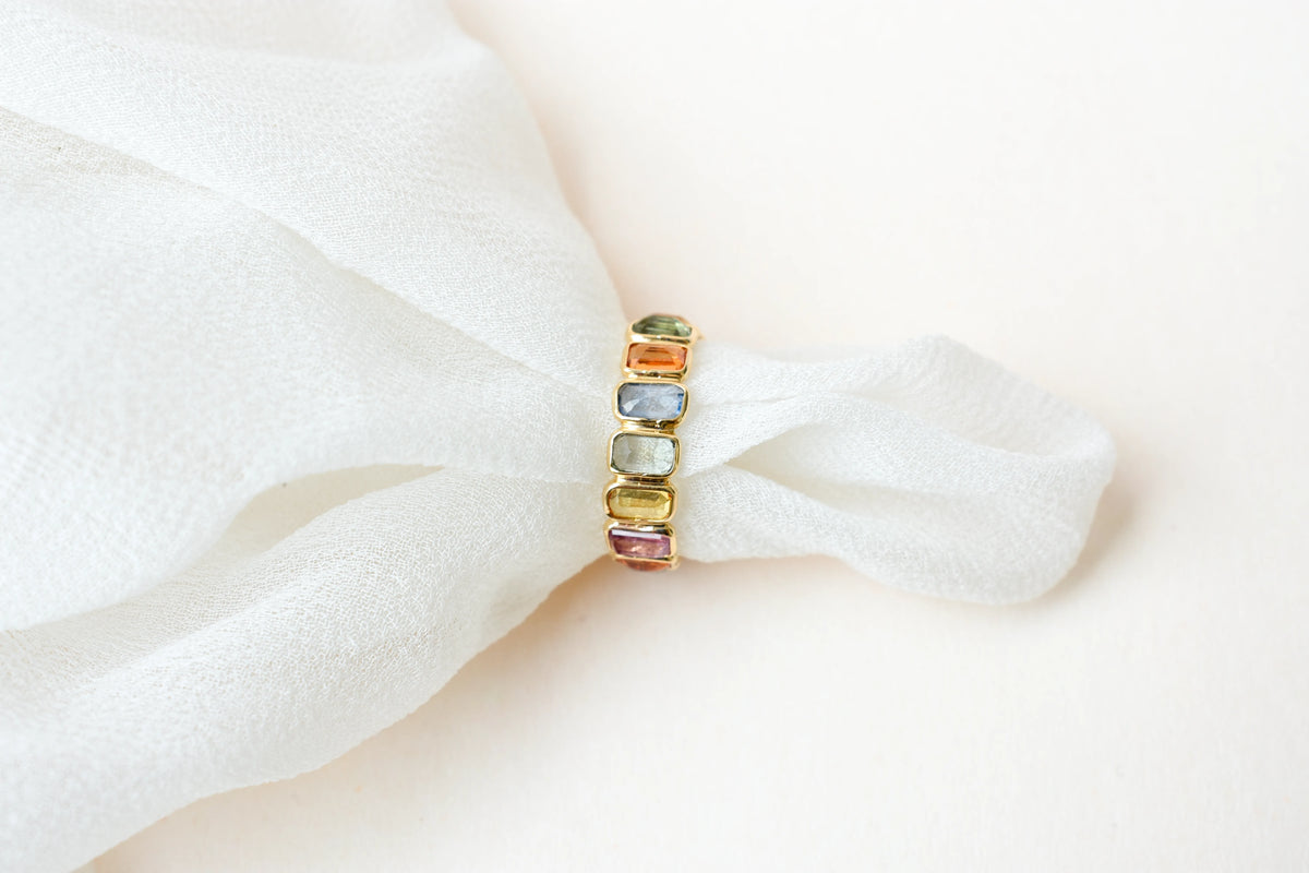 Emerald-cut multicolor sapphire eternity ring in 18K gold
