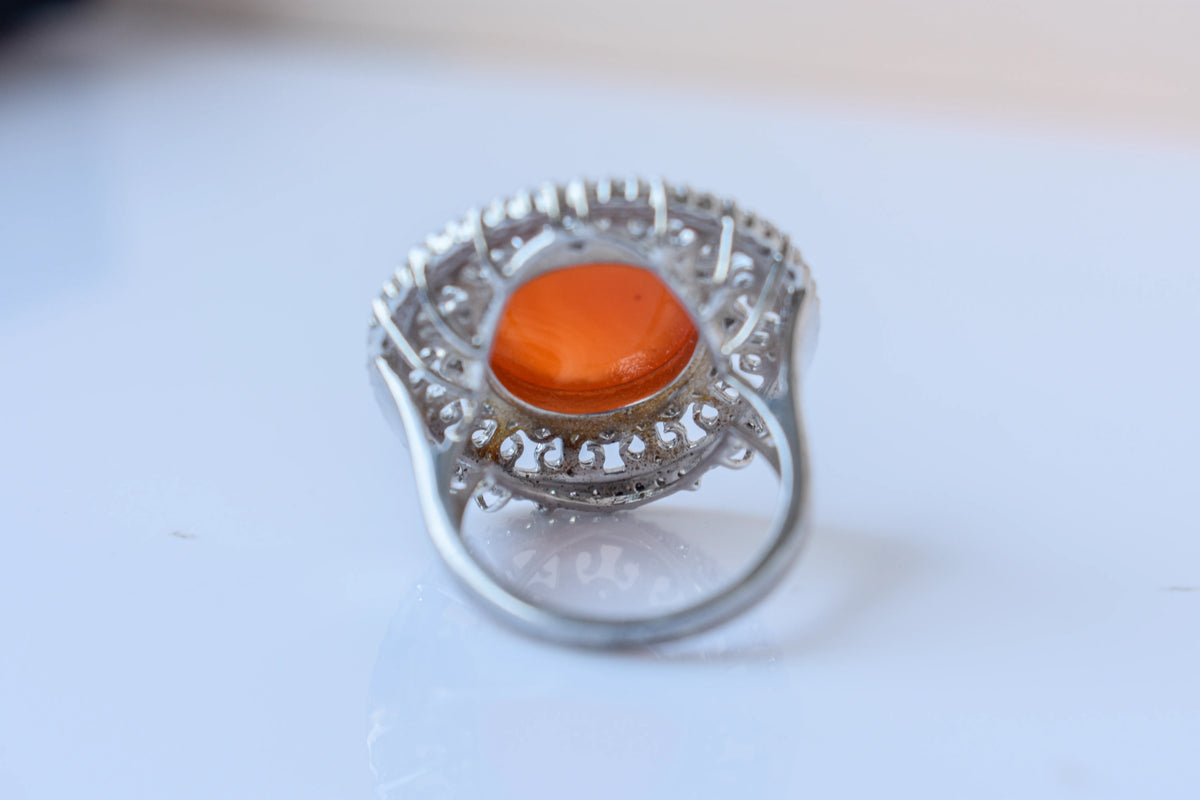 Orange cabochon gemstone ring in 925 silver with ornate scrollwork setting