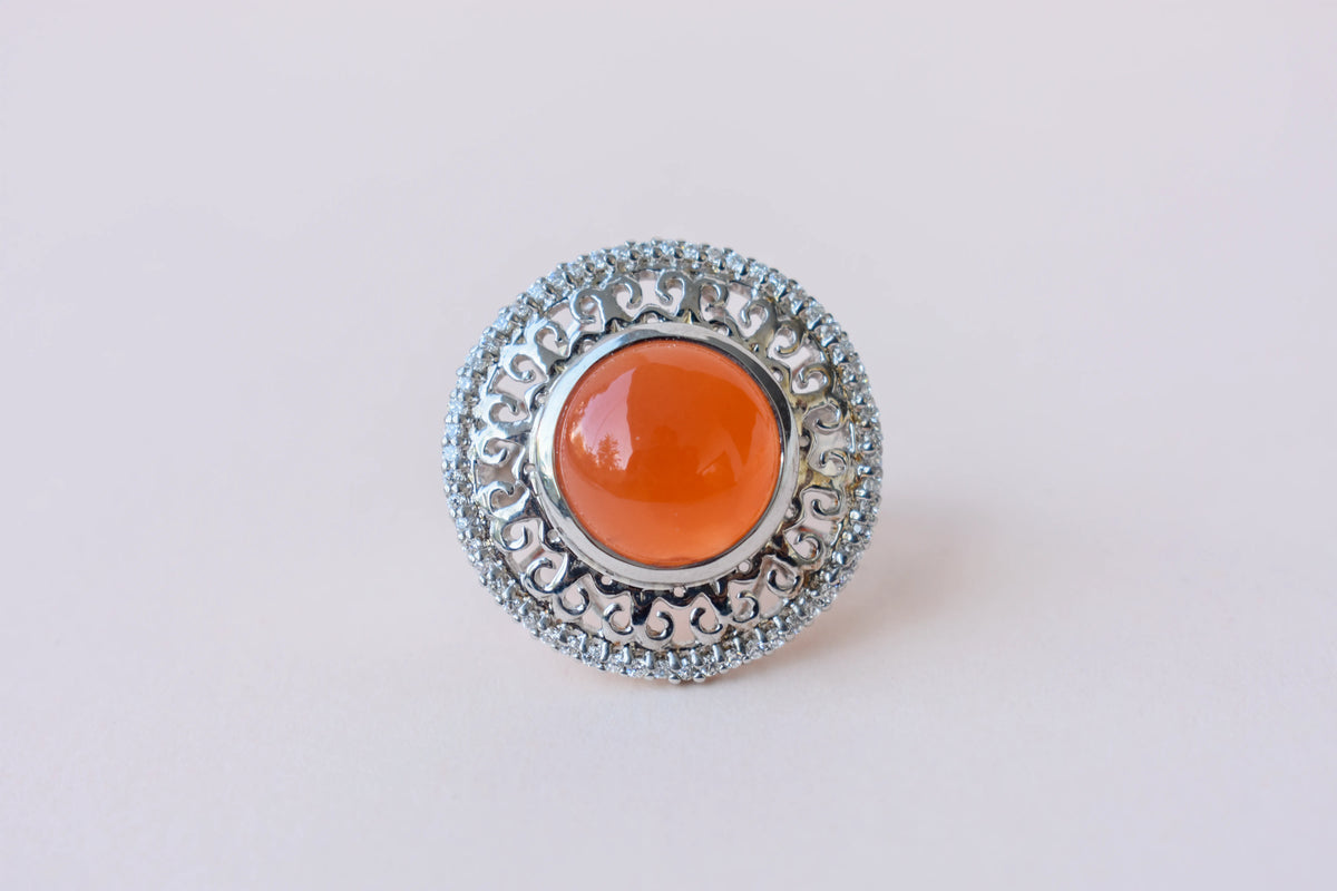 Orange cabochon gemstone ring in 925 silver with ornate scrollwork setting