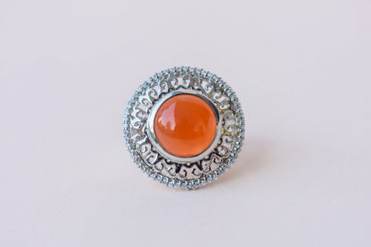 Orange cabochon gemstone ring in 925 silver with ornate scrollwork setting