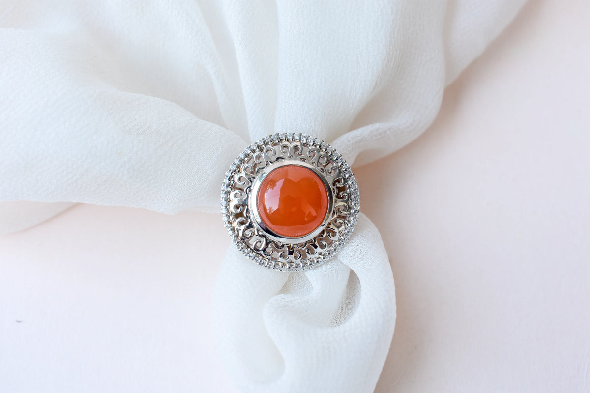 Orange cabochon gemstone ring in 925 silver with ornate scrollwork setting
