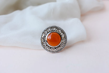 Orange cabochon gemstone ring in 925 silver with ornate scrollwork setting