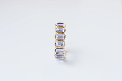 Emerald-cut tanzanite single-row eternity ring in 18K gold