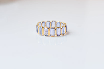 Emerald-cut tanzanite single-row eternity ring in 18K gold