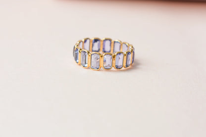 Emerald-cut tanzanite single-row eternity ring in 18K gold