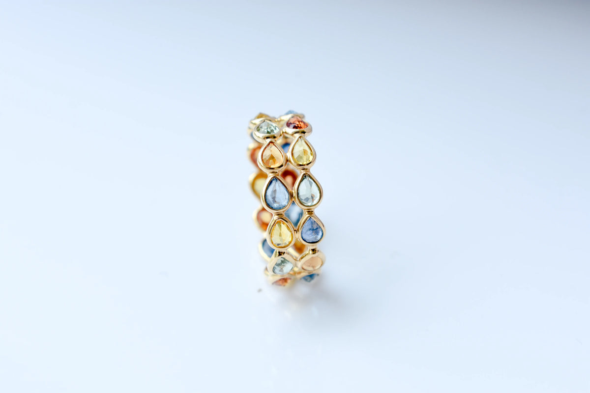 Pear-cut multicolor sapphire woven eternity ring in 18K gold, blue tones