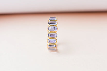 Emerald-cut tanzanite single-row eternity ring in 18K gold