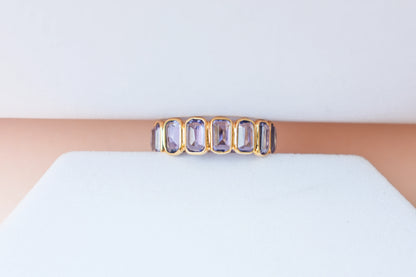 Emerald-cut tanzanite single-row eternity ring in 18K gold