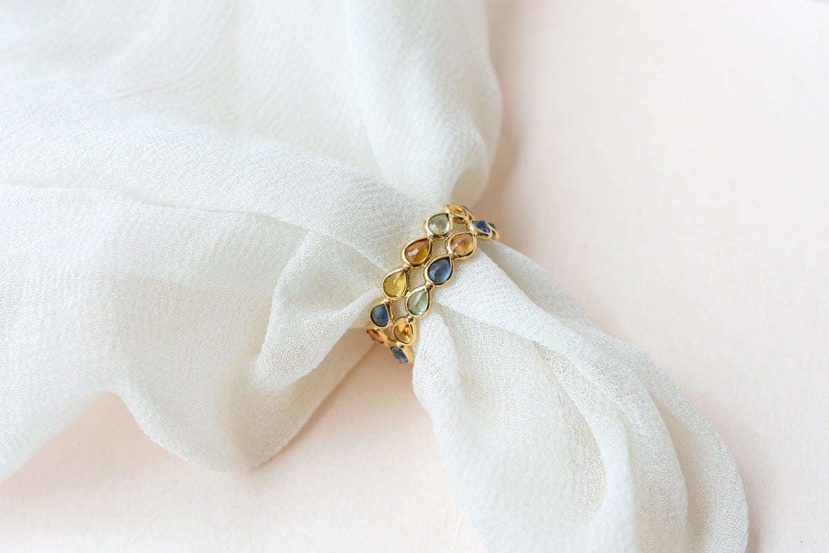 Pear-cut multicolor sapphire woven eternity ring in 18K gold, blue tones