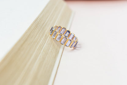 Emerald-cut tanzanite single-row eternity ring in 18K gold