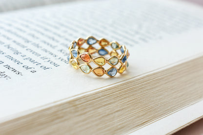 Pear-cut multicolor sapphire woven eternity ring in 18K gold, blue tones