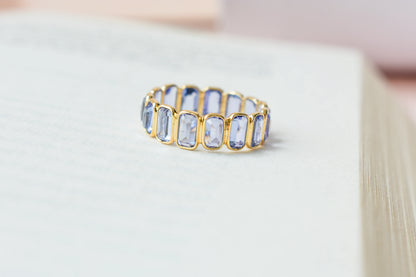 Emerald-cut tanzanite single-row eternity ring in 18K gold