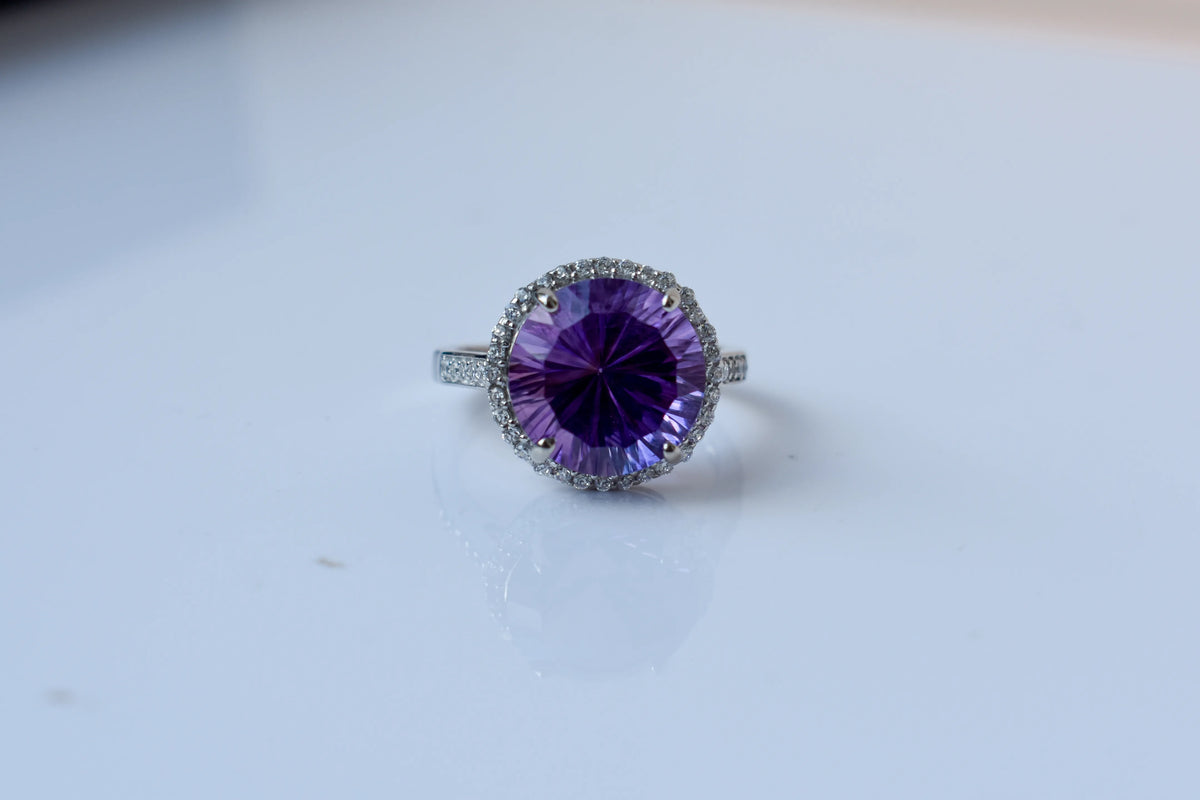 Round amethyst halo ring in 925 silver with fan-faceted cut and cubic zirconia border