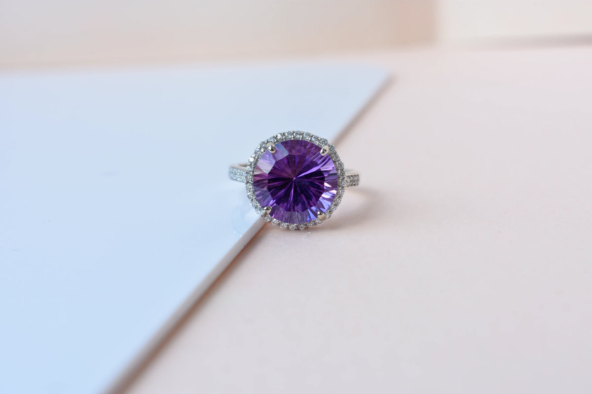 Round amethyst halo ring in 925 silver with fan-faceted cut and cubic zirconia border