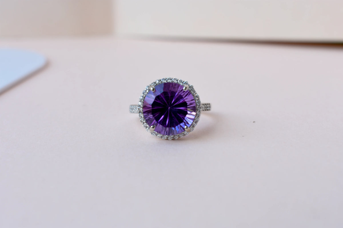Round amethyst halo ring in 925 silver with fan-faceted cut and cubic zirconia border