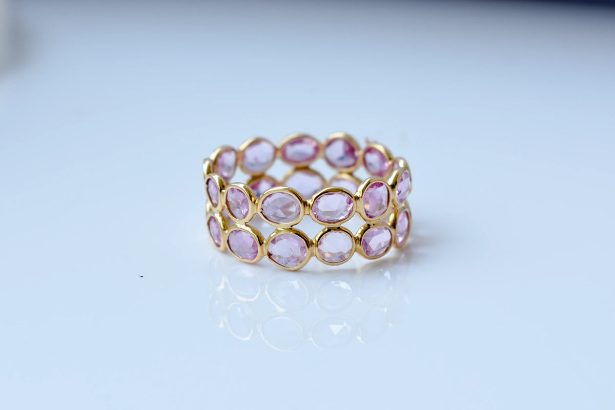 Oval-cut pink sapphire double-row eternity ring in 18K gold