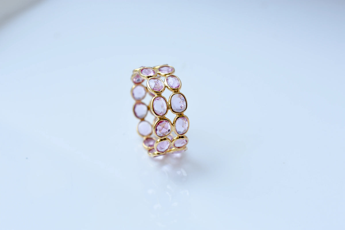 Oval-cut pink sapphire double-row eternity ring in 18K gold