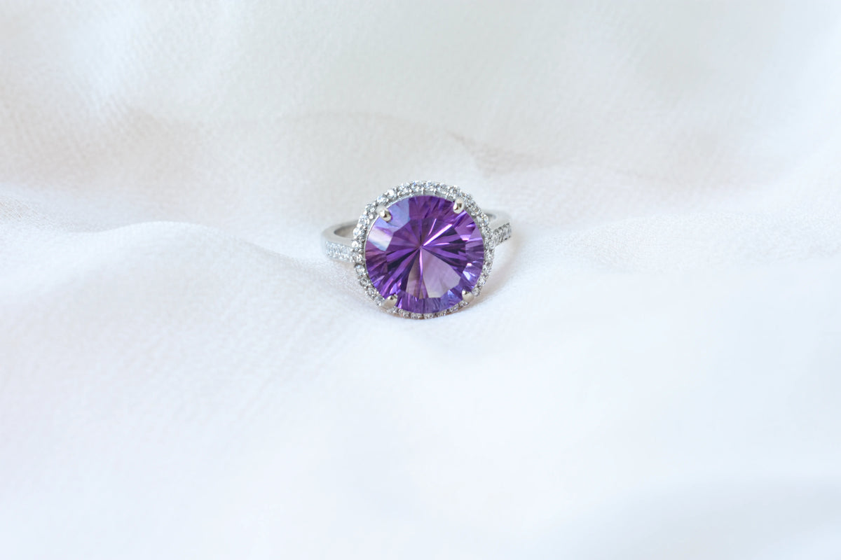 Round amethyst halo ring in 925 silver with fan-faceted cut and cubic zirconia border
