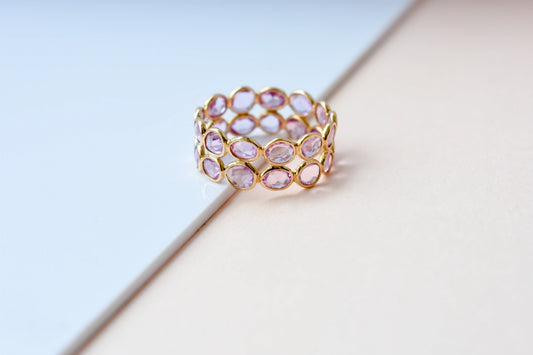 Oval-cut pink sapphire double-row eternity ring in 18K gold