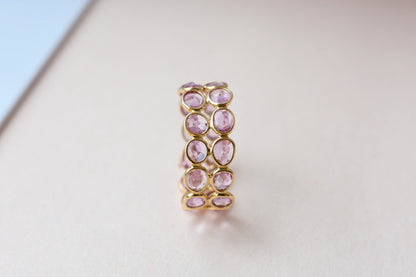 Oval-cut pink sapphire double-row eternity ring in 18K gold