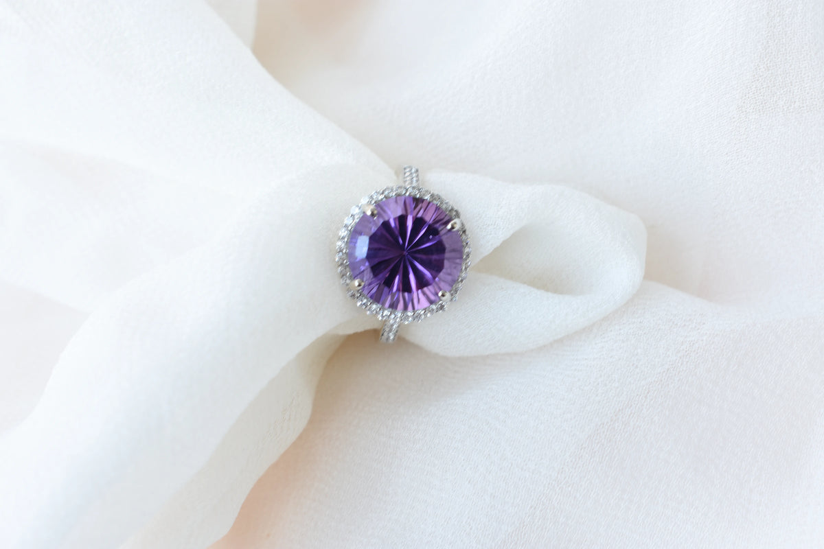 Round amethyst halo ring in 925 silver with fan-faceted cut and cubic zirconia border