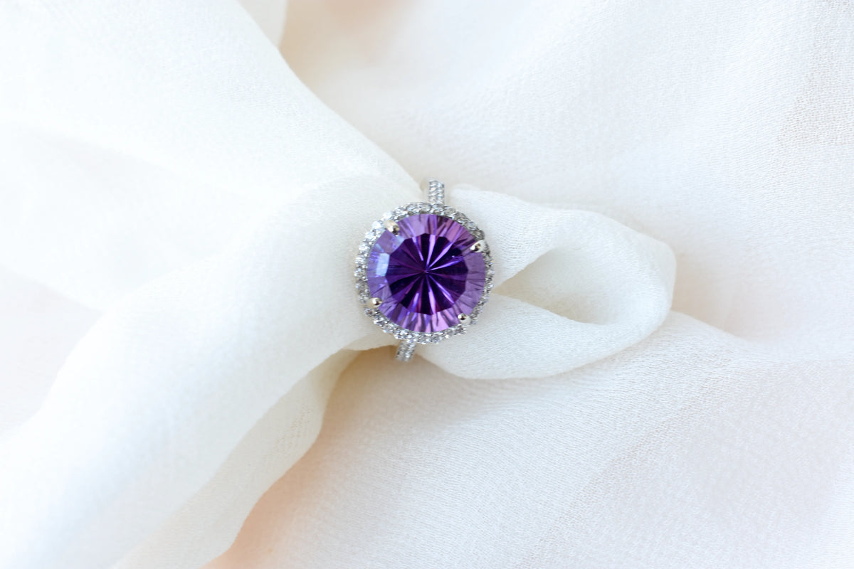 Round amethyst halo ring in 925 silver with fan-faceted cut and cubic zirconia border