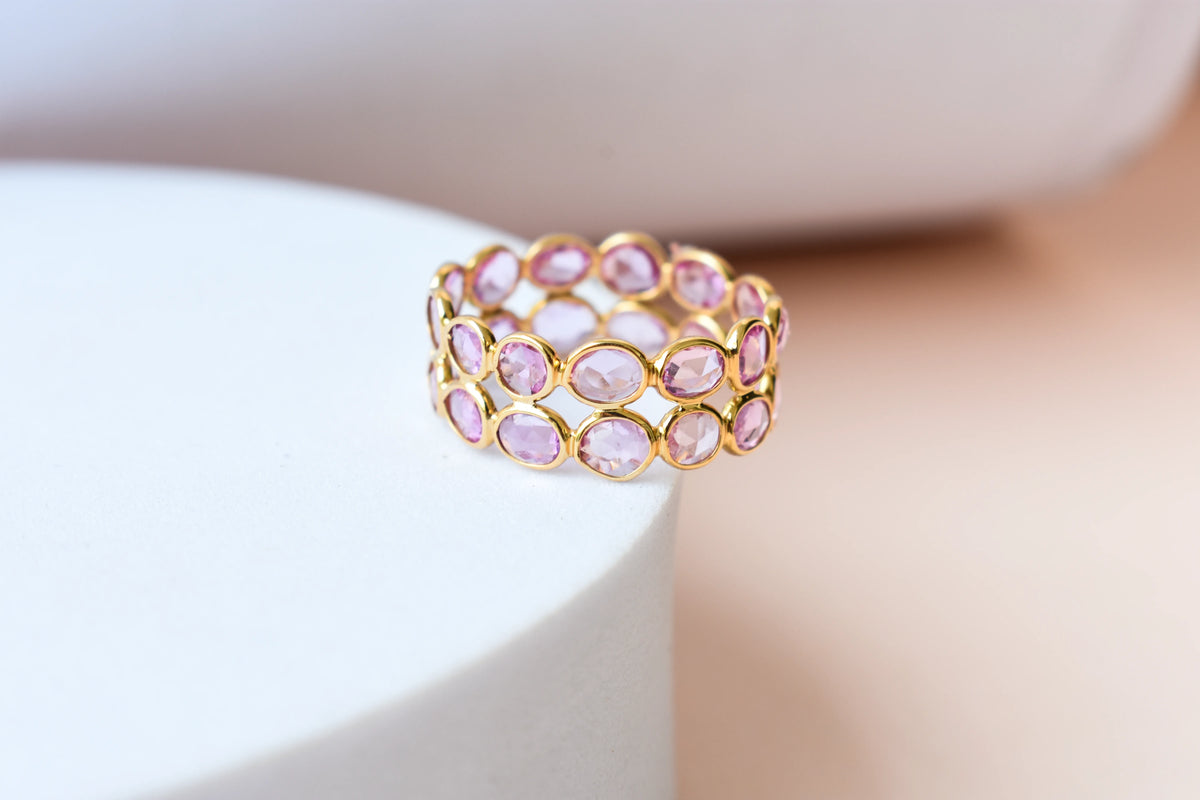 Oval-cut pink sapphire double-row eternity ring in 18K gold