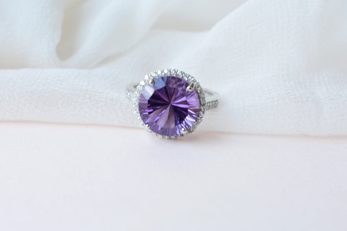 Round amethyst halo ring in 925 silver with fan-faceted cut and cubic zirconia border