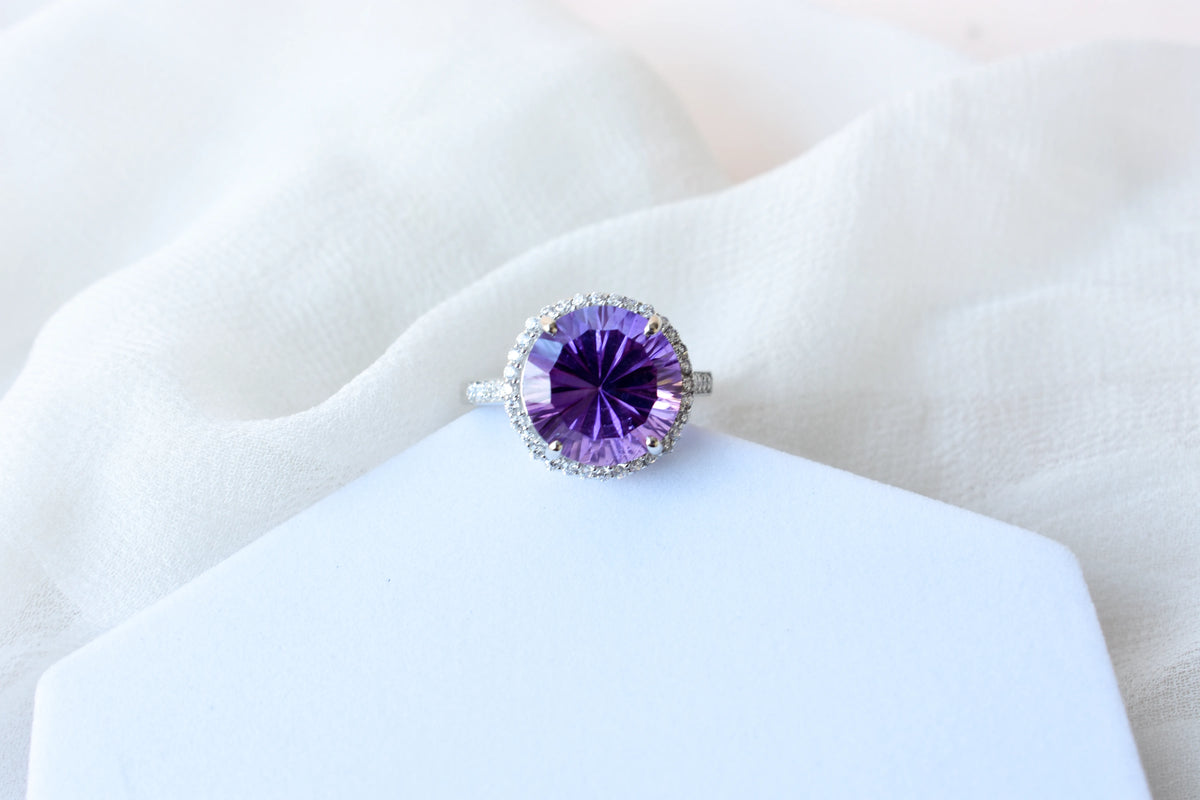 Round amethyst halo ring in 925 silver with fan-faceted cut and cubic zirconia border