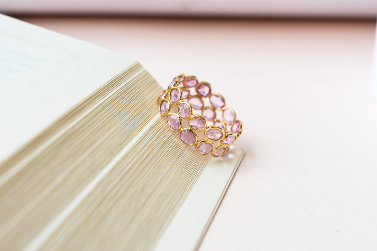 Oval-cut pink sapphire double-row eternity ring in 18K gold