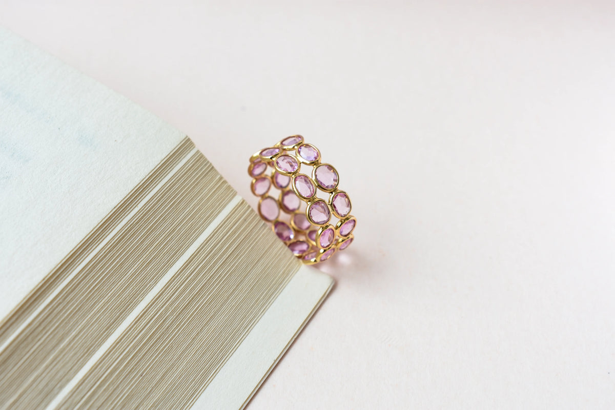 Oval-cut pink sapphire double-row eternity ring in 18K gold