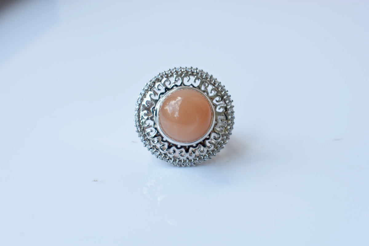 Peach moonstone cabochon ring in 925 silver with ornate scrollwork setting