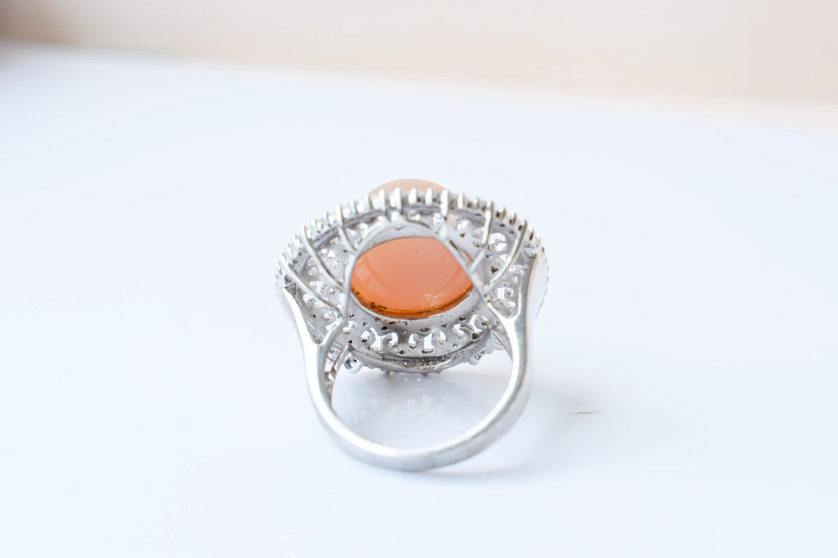 Peach moonstone cabochon ring in 925 silver with ornate scrollwork setting