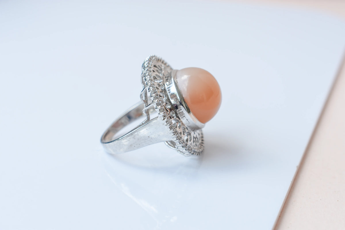 Peach moonstone cabochon ring in 925 silver with ornate scrollwork setting