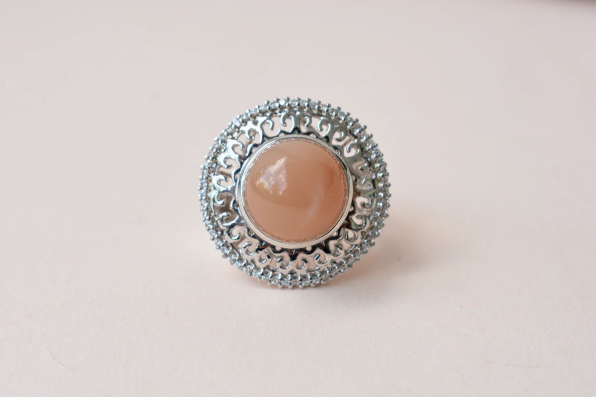 Peach moonstone cabochon ring in 925 silver with ornate scrollwork setting